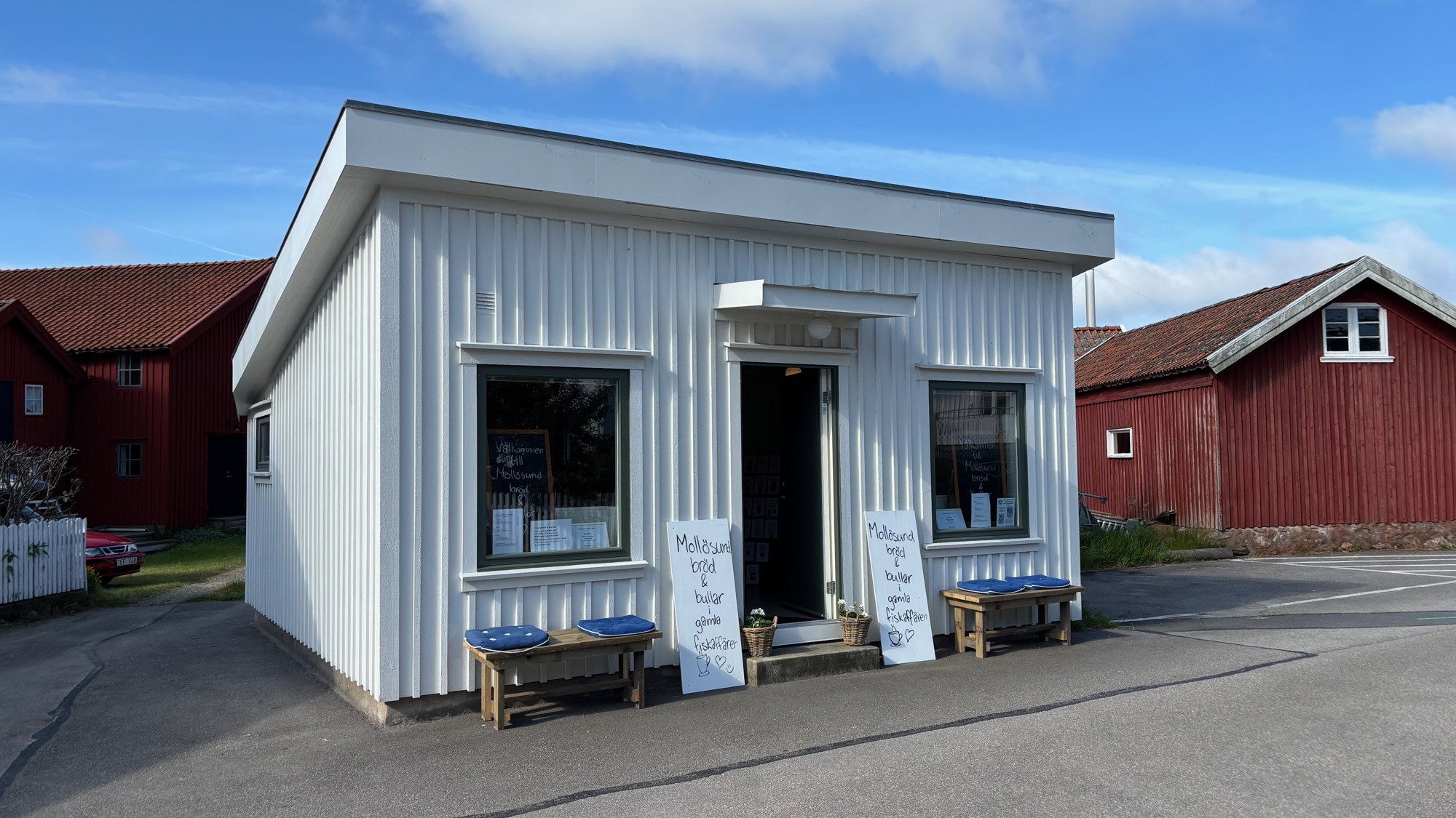 Vår vita träbutik i gamla fiskaffären på Sandvägen, med blå dynor på bänkarna utanför